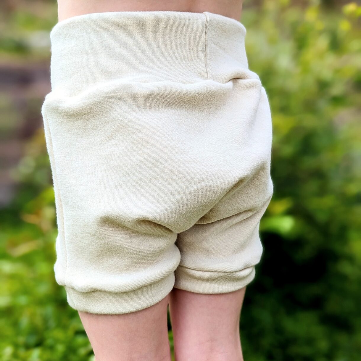 Merino Wool Shorties in Natural Cream Color modeled for fit showing extra room in front and back to pair with a cloth diaper or to be worn as a normal article of clothing