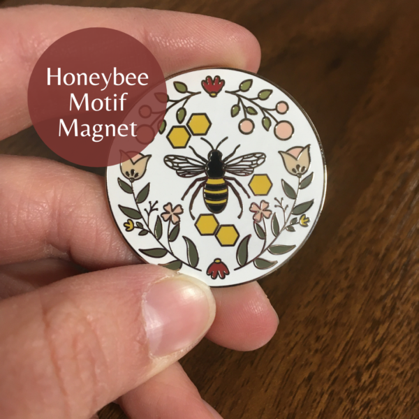 picture of a magnet with a honeybee in the center and flowers around the edges