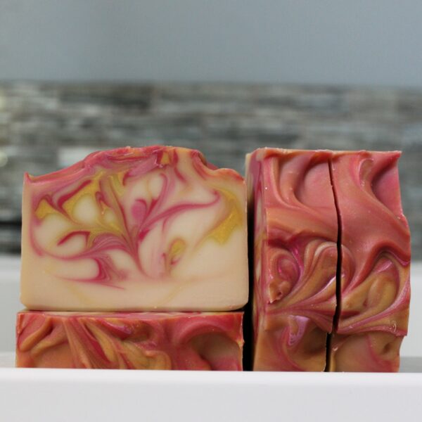 Pink yellow cream colored bar soap in fruity scent