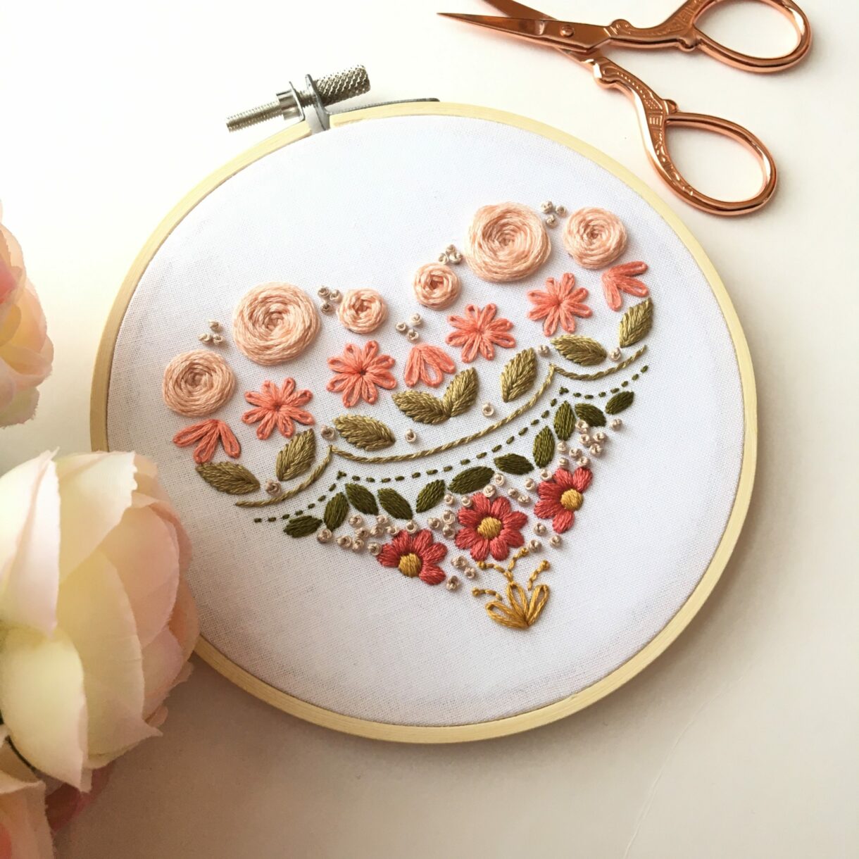 picture of hand stitched embroidery sampler in a heart shape
