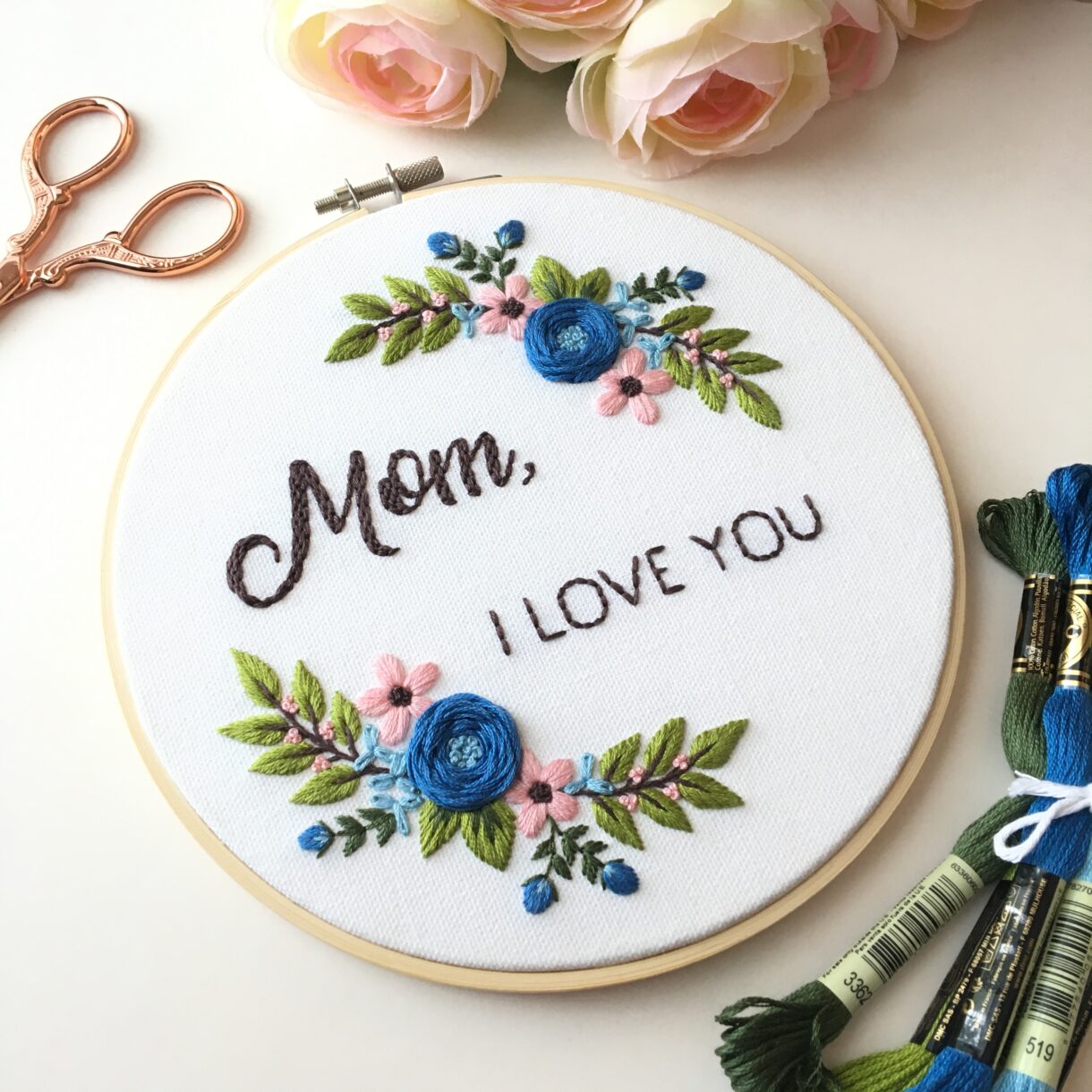 picture of hand embroidered florals in wreath with the words "Mom, I love you" in the center