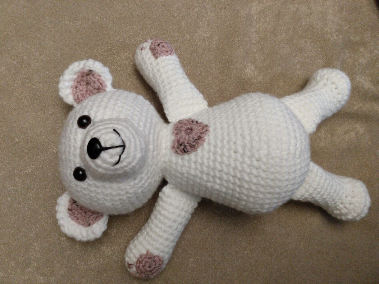White and pink bear laying