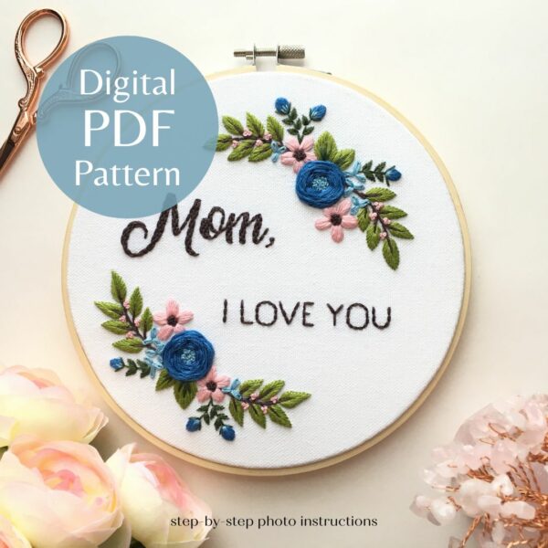 picture of hand embroidery in a floral wreath with the words "mom, I love you" in the center