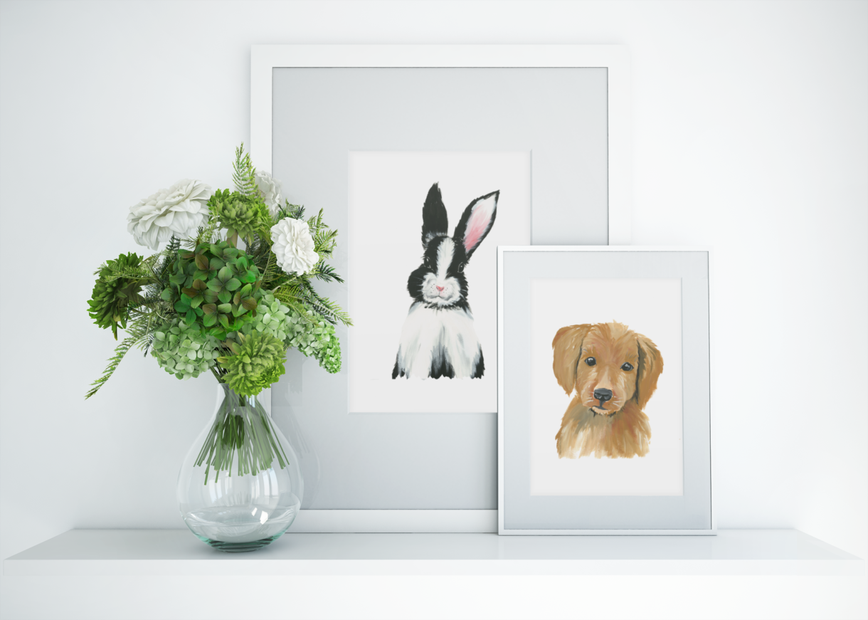 bunny and puppy art print frames sitting on table beside vase and flowers