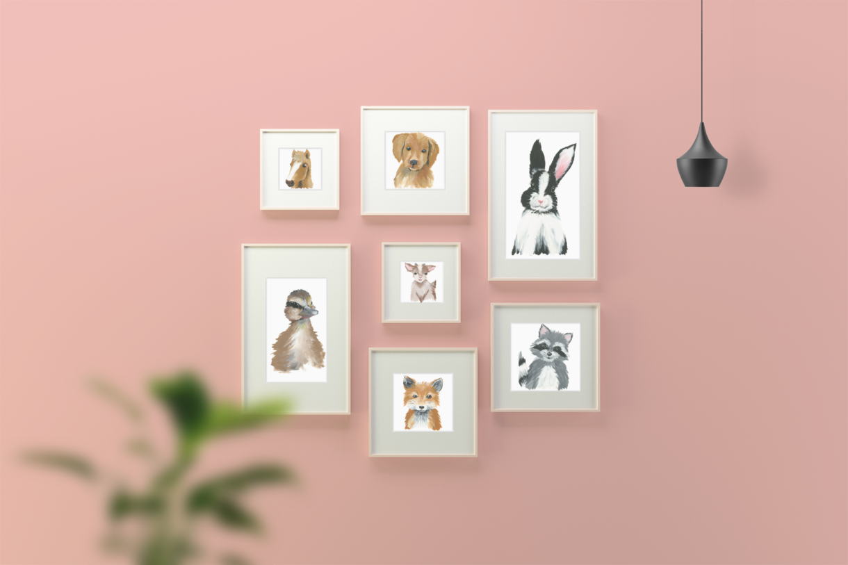 seven nursery art print frames on pink wall